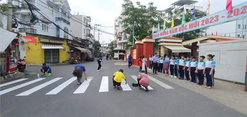Trường THCS An Nhơn phối hợp với Đoàn Phường 6, Công An Phường 6 thực hiện quét dọn và sơn sửa trước cổng trường.
